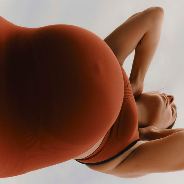 Pregnant female body wearing Jorgen House brick red colour high waist maternity spiorts leggings and maternity breastfeeding sports bra
