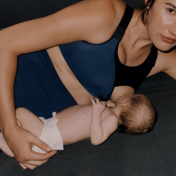 Female breastfeeding her newborn wearing Jorgen House midnight blue colour high waist sports leggings and maternity breastfeeding sports bra