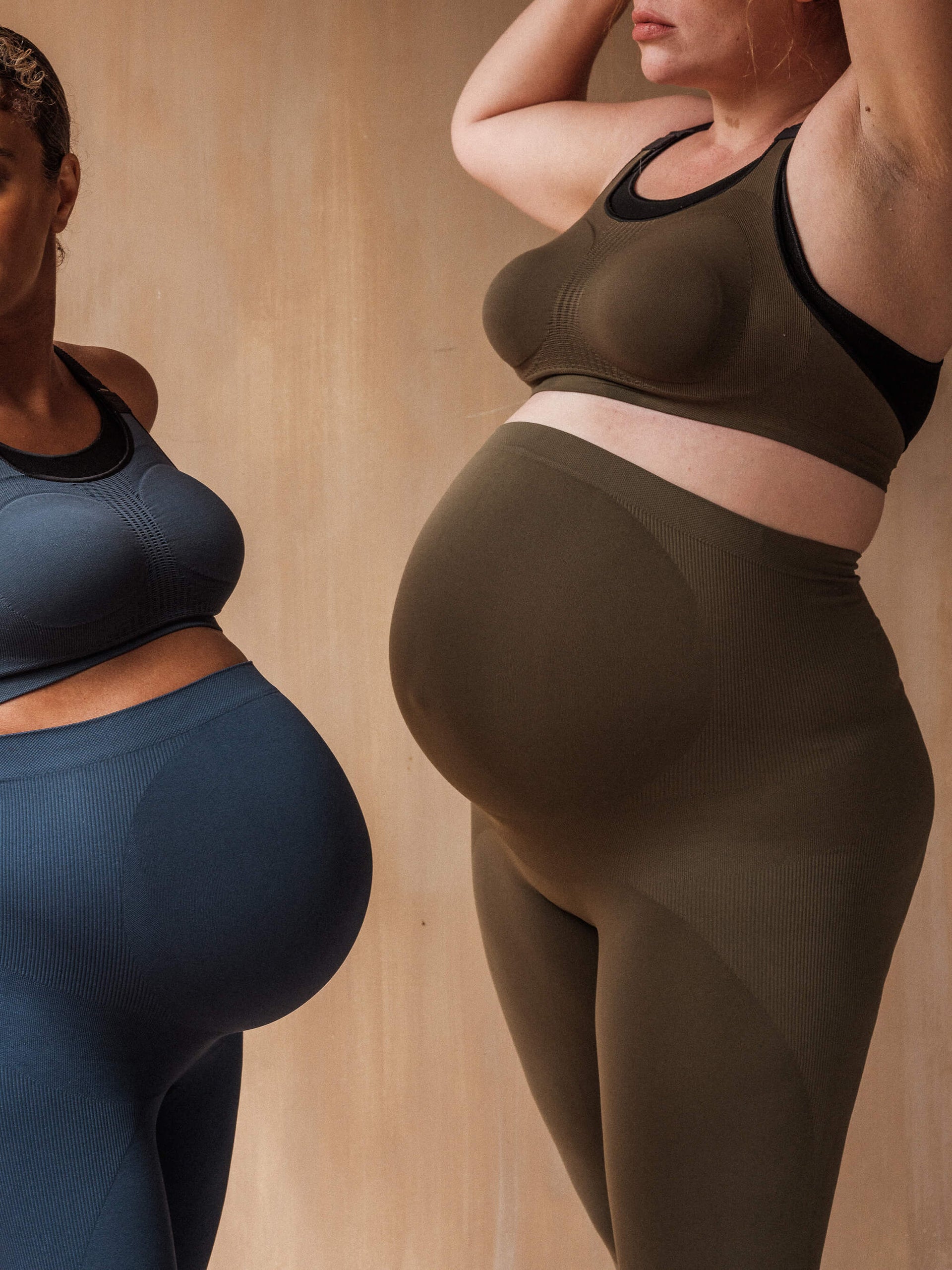 Jorgen House image of two women wearing the midnight blue and dark olive green maternity breastfeeding bra and high waist leggings on pregnant female bodies