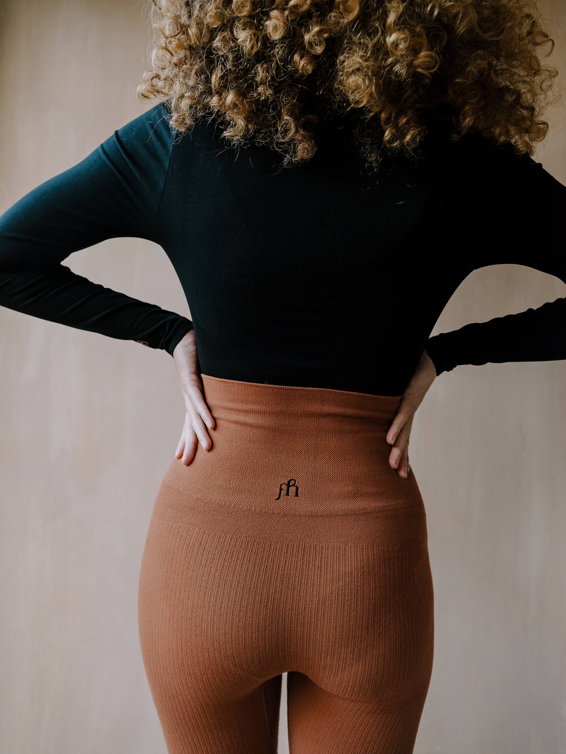 Jorgen House  Black long sleeve bodysuit and ginger colour high waist leggings on female body