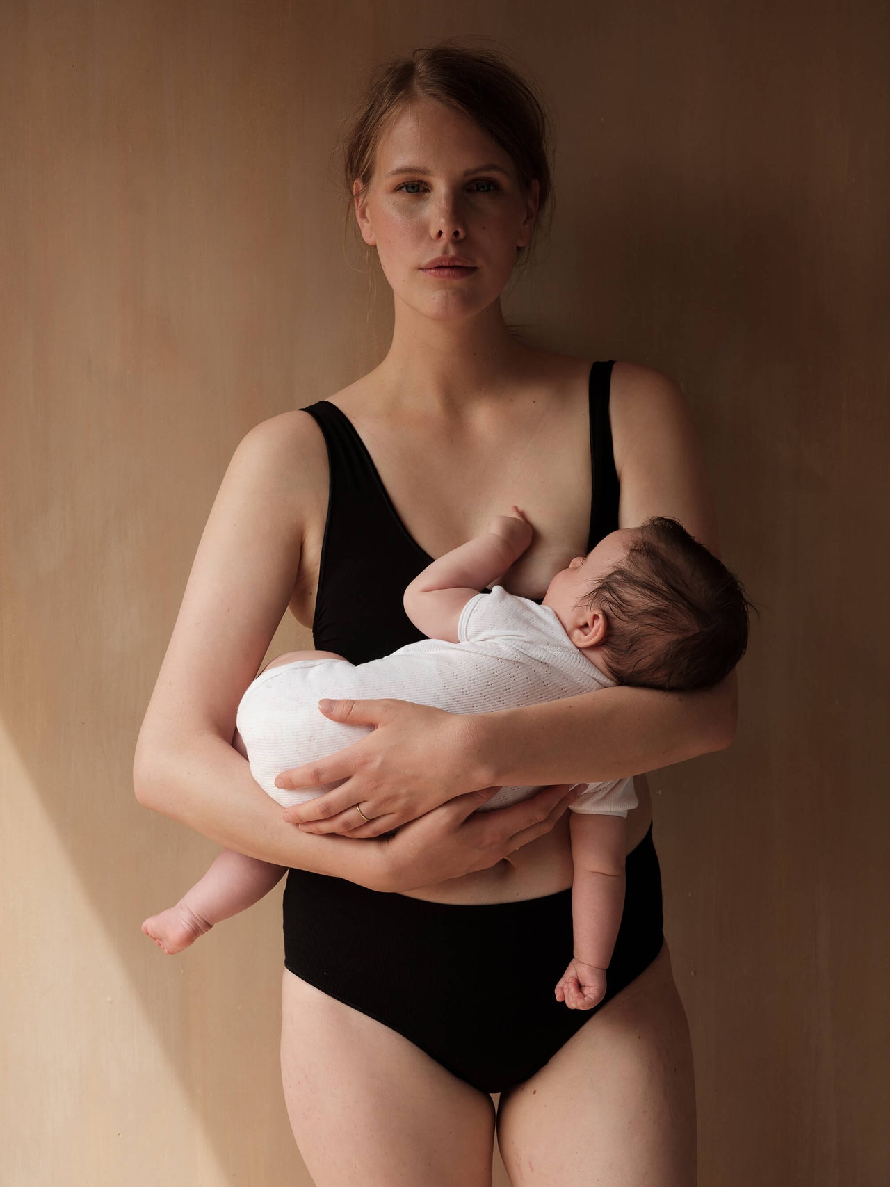 Jorgen House black colour cleep maternity breastfeeding bra and briefs on a female body feeding her baby