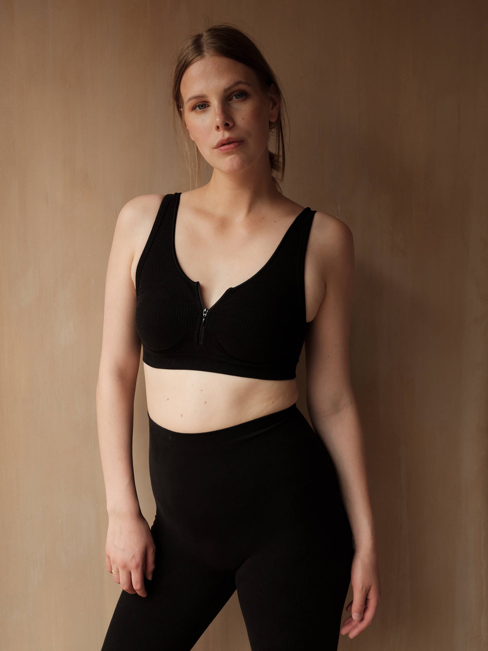Jorgen House  Black zip front crop bra and high waist leggings on female body