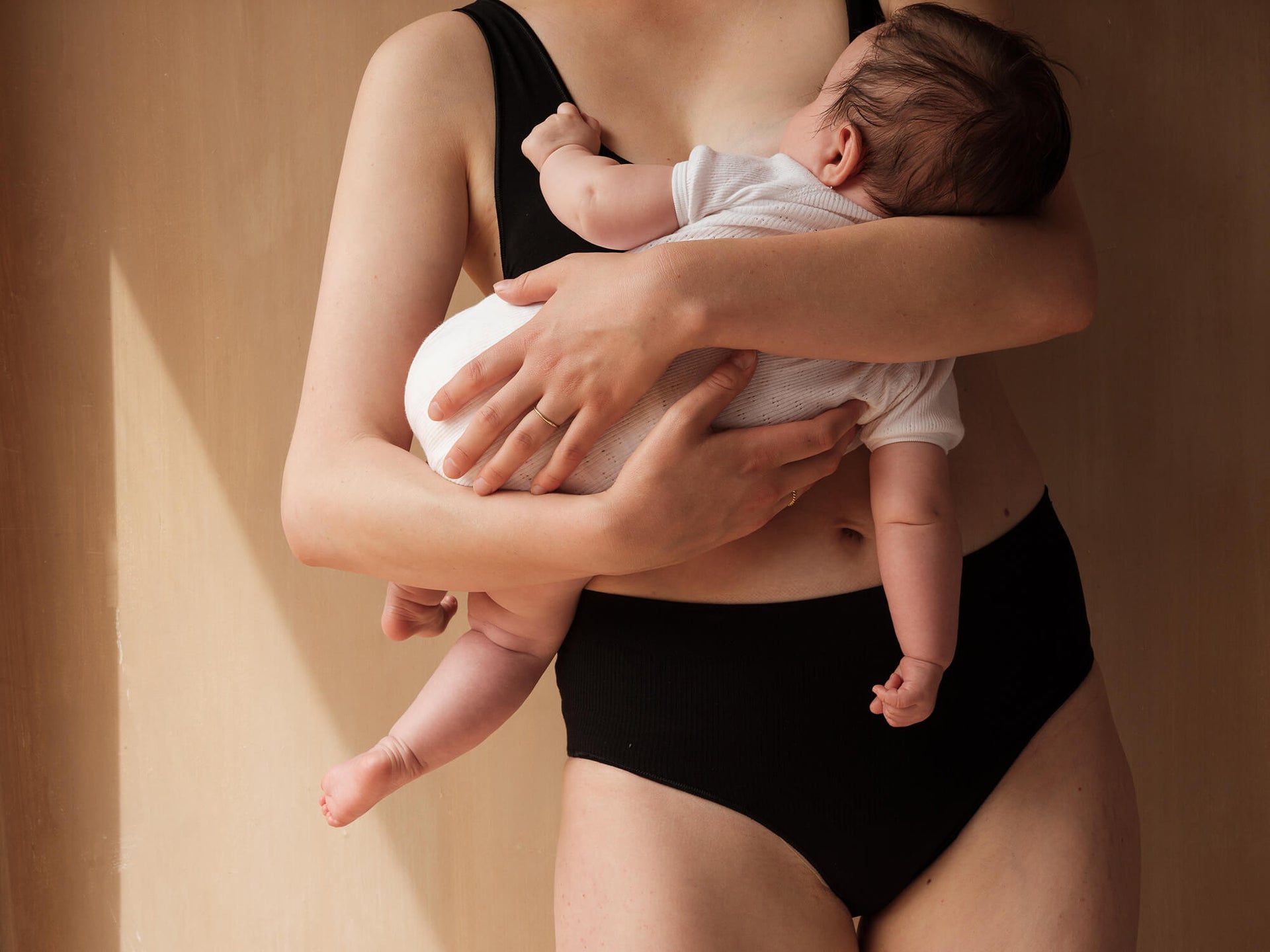 Jorgen House black support briefs on female body breastfeeding her baby
