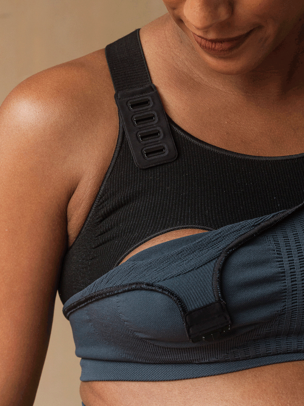 GIF showing a woman using the innovative clasps on the Jorgen House midnight blue maternity breastfeeding sports bra