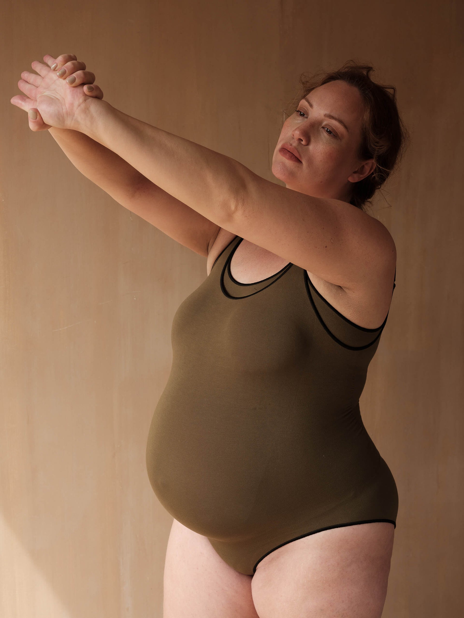 Jorgen House Dark olive green maternity strap bodysuit on pregnant female body